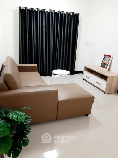 Cozy living room with modern sofa and elegant curtains, perfect for relaxation.