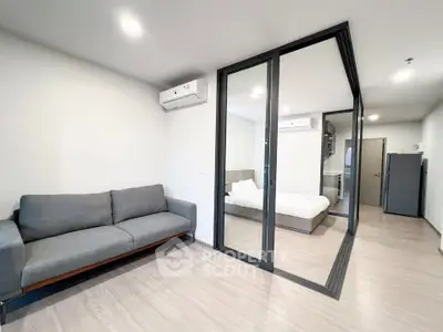 Modern apartment interior with glass partition, cozy living room, and stylish bedroom.