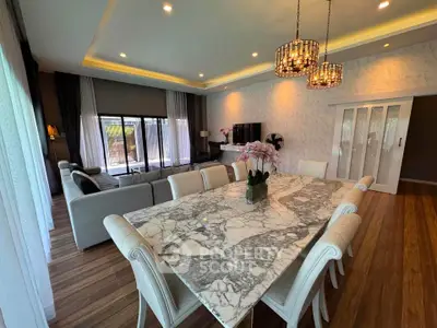 Luxurious open-plan living and dining area with elegant marble table and stylish lighting.