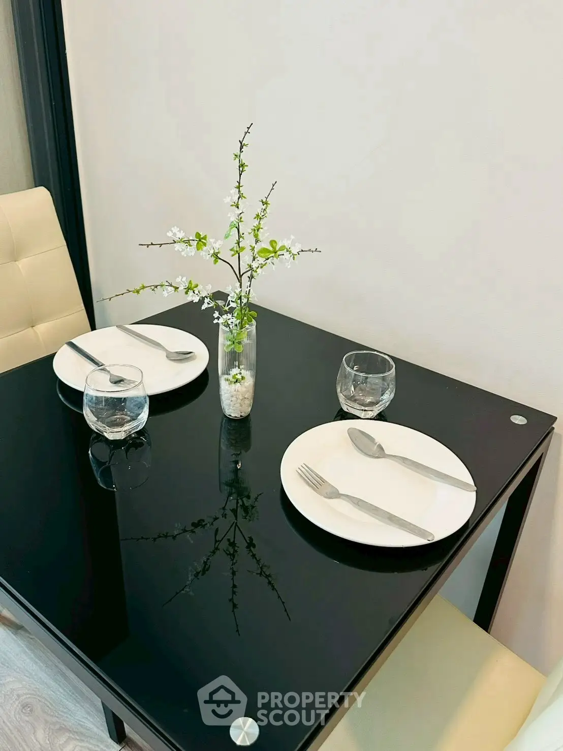 Elegant dining setup with black glass table and modern decor