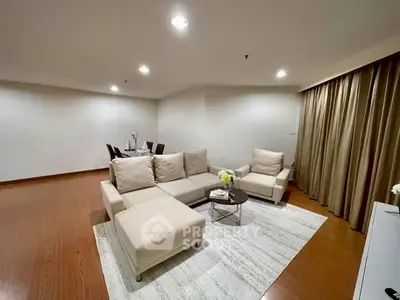 Spacious modern living room with elegant furniture and warm lighting, perfect for relaxation and entertaining.
