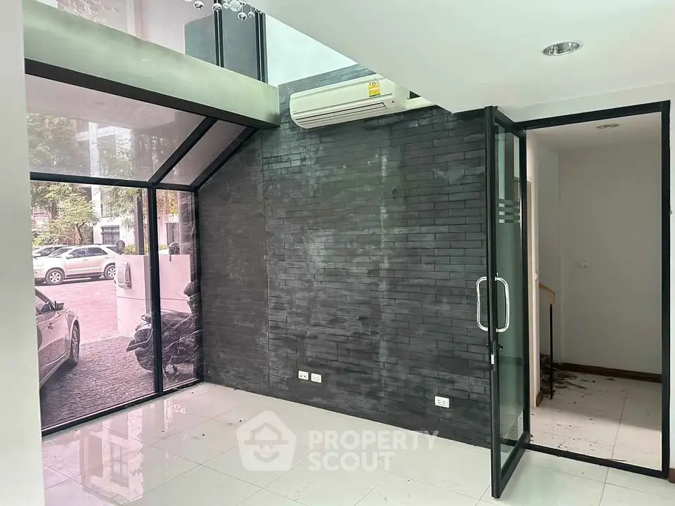 Modern office space with glass walls and sleek black accents, ideal for a professional setting.
