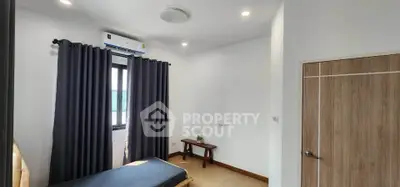 Cozy bedroom with modern decor and natural light, featuring a single bed and stylish curtains.