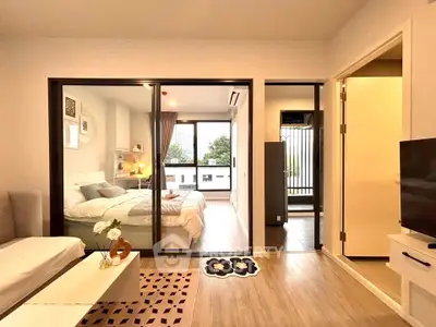 Modern bedroom with sliding glass doors and cozy decor in a stylish apartment.