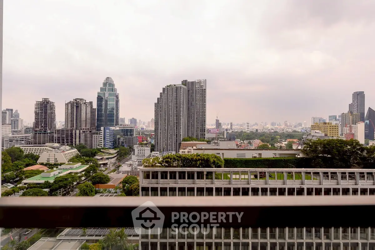 Stunning cityscape view from a high-rise balcony showcasing urban skyline and lush greenery.
