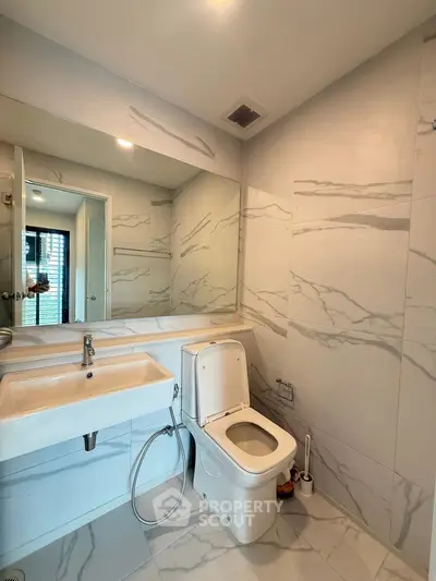 Modern bathroom with marble tiles and sleek fixtures in a contemporary home.