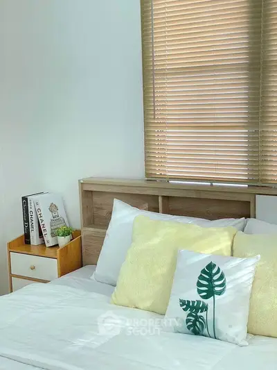 Cozy bedroom with stylish decor and natural light, featuring a comfortable bed and chic window blinds.