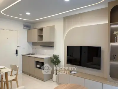 Modern open-layout kitchen and living area with sleek cabinetry and built-in TV unit.