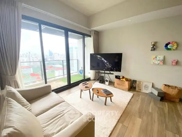 Modern living room with city view, featuring cozy sofa and large TV, perfect for relaxation.