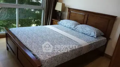 Cozy bedroom with wooden bed frame and large window view