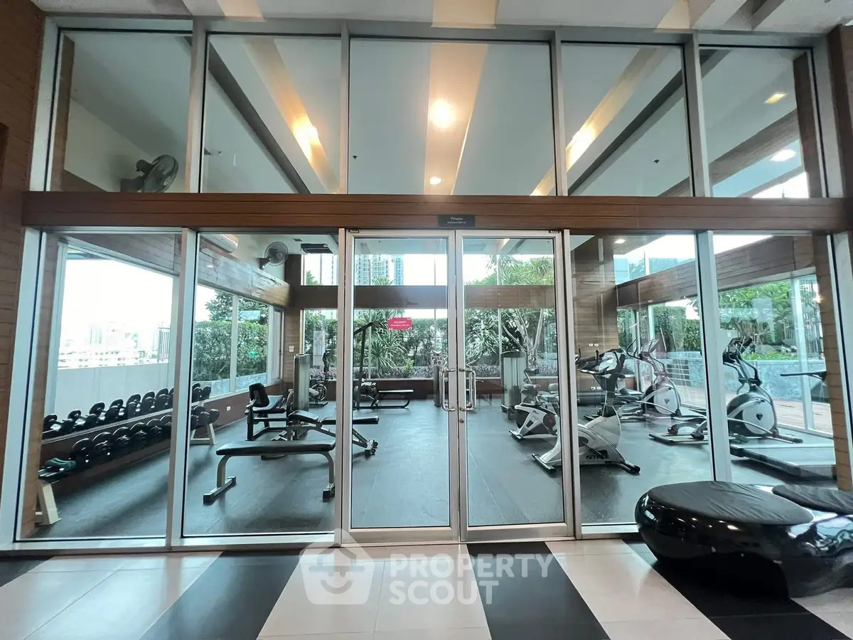 Modern gym with glass walls and fitness equipment in luxury building