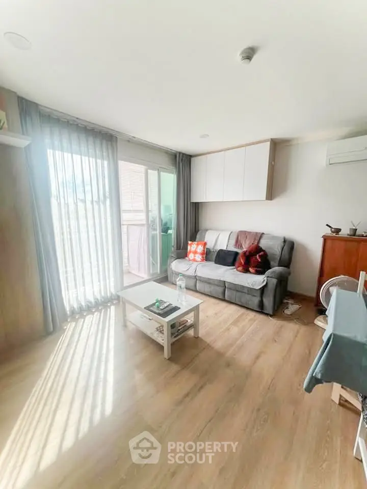 Bright living room with cozy sofa and sliding glass doors to balcony