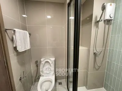 Modern bathroom with sleek shower and toilet in contemporary apartment.