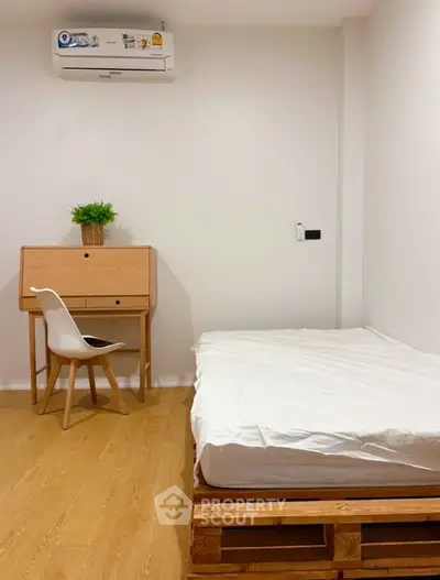 Cozy minimalist bedroom with wooden furniture and air conditioning