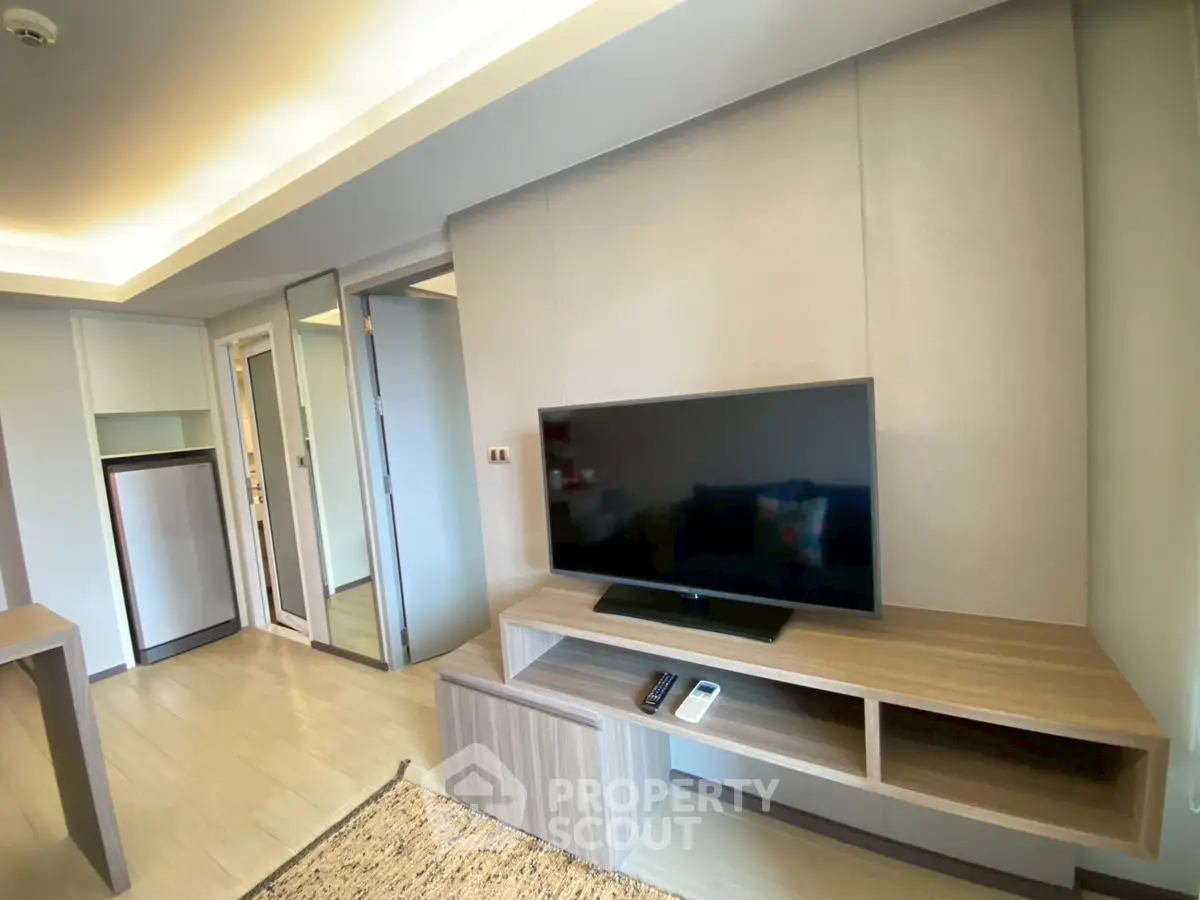 Modern living room with sleek TV stand and ambient lighting in a stylish apartment.