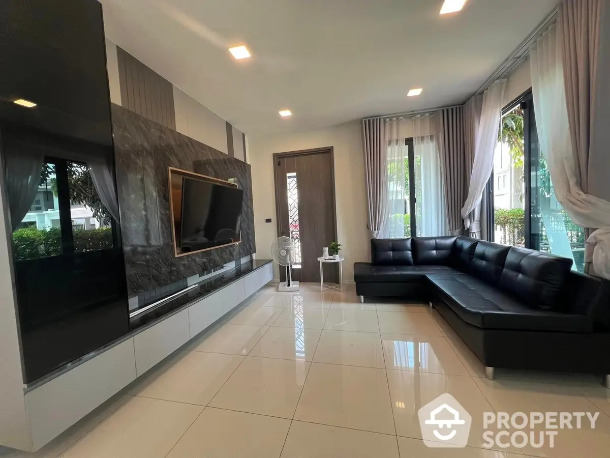 Spacious living room with glossy tiled floors, modern furniture, and large windows draped in elegant curtains, creating a luxurious and inviting atmosphere.