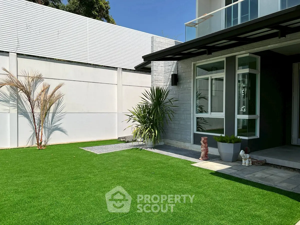 Modern home exterior with lush green lawn and contemporary design elements.