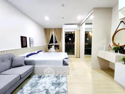 Modern studio apartment with cozy bed, stylish decor, and balcony view