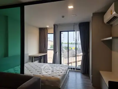 Modern bedroom with balcony and city view, featuring sleek design and ample natural light.