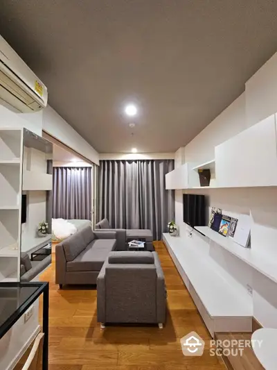 Elegant living room with modern furniture, warm wooden flooring, and tasteful neutral color palette, perfect for relaxation and entertaining guests.