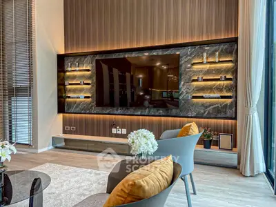 Luxurious modern living room with stylish decor and large TV, perfect for relaxation and entertainment.