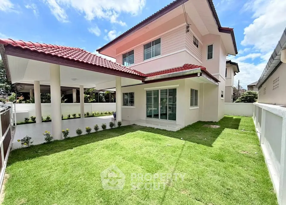 Charming two-story house with lush green lawn and covered patio, perfect for family living.