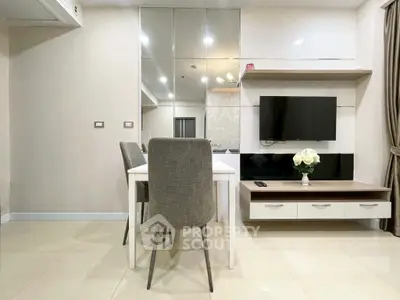 Modern living room with sleek furniture and wall-mounted TV in stylish apartment.