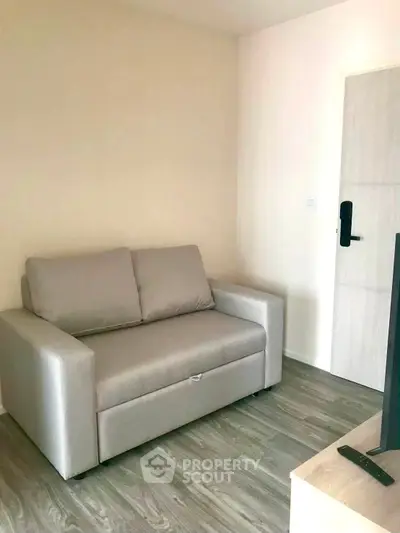 Cozy living room with modern sofa and sleek flooring, perfect for relaxation.