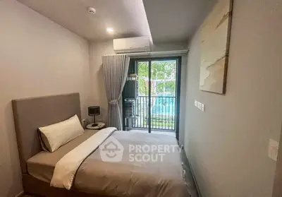 Cozy bedroom with balcony view overlooking a serene pool area.