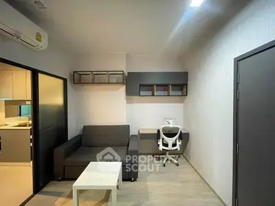 Modern living room with sleek furniture and study area in a stylish apartment.