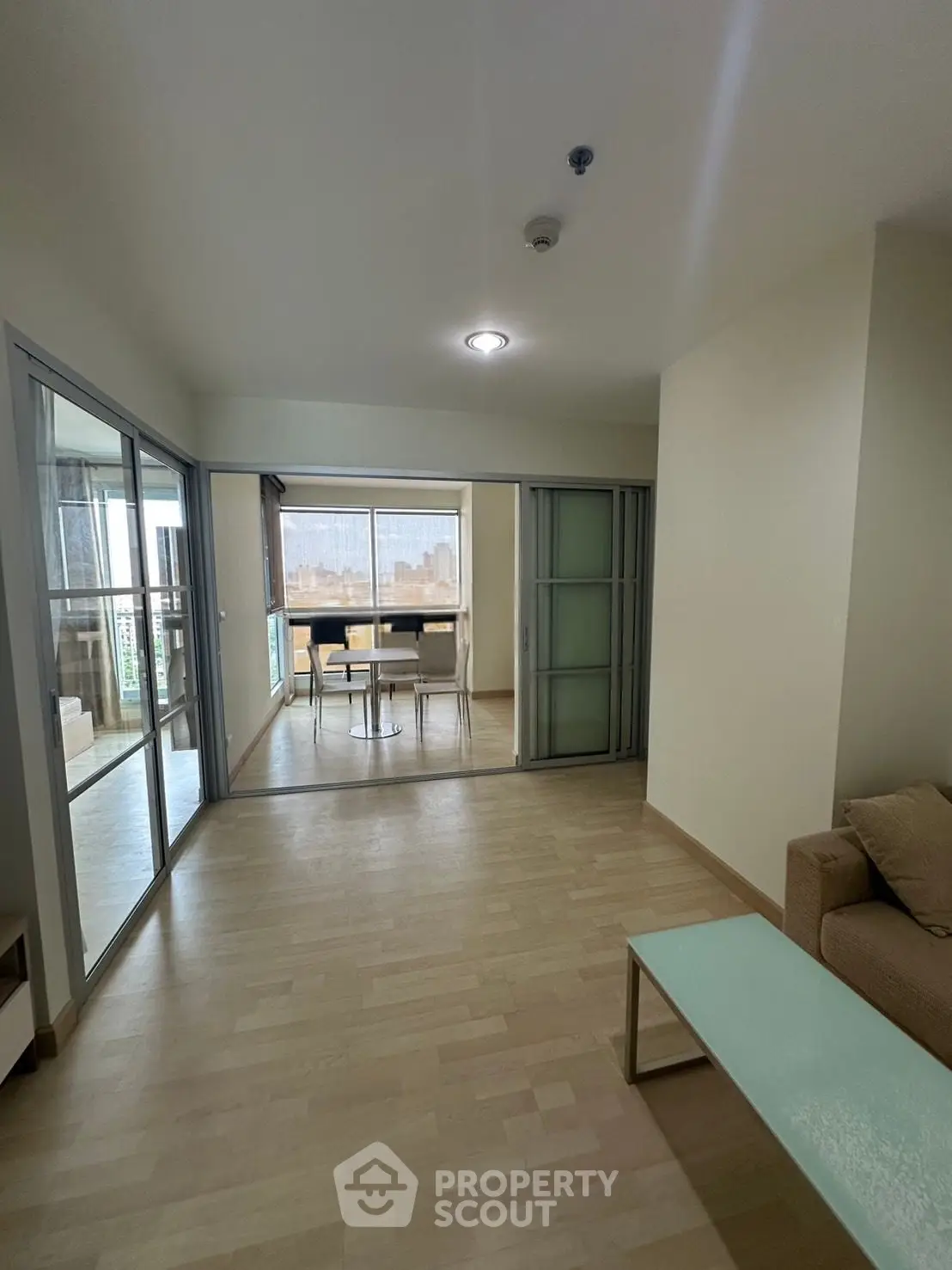 Spacious living room with sliding glass doors leading to a bright dining area and balcony view.
