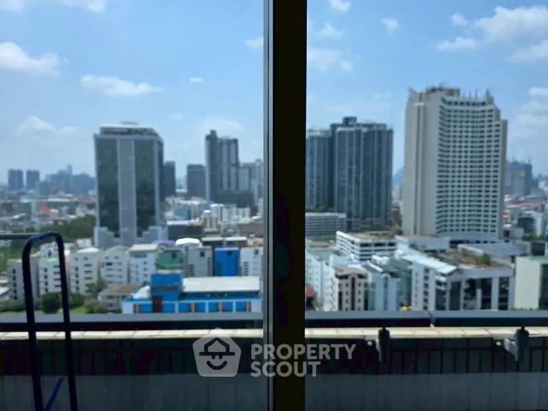 Stunning cityscape view from a high-rise balcony with modern skyscrapers.