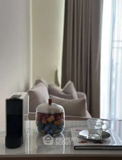 Cozy living room corner with coffee machine and plush seating, perfect for relaxation.