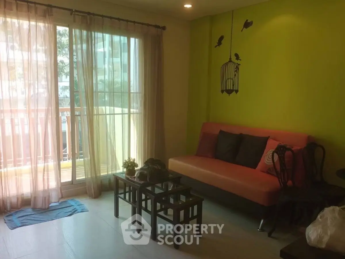 Charming living room with vibrant green accent wall and cozy seating area.