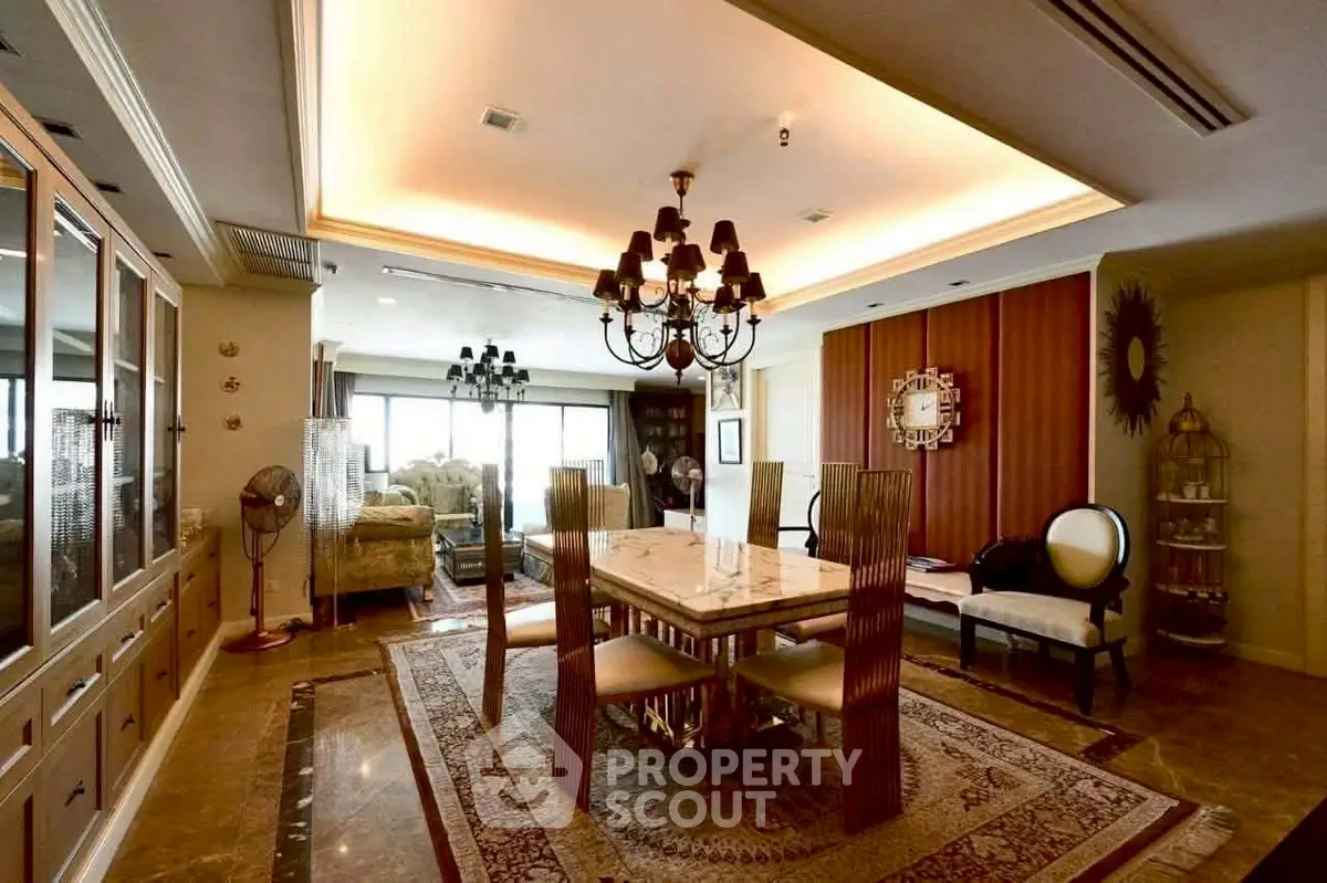 Luxurious dining room with elegant chandelier and marble table in a spacious open layout.