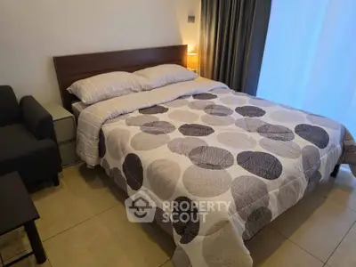 Cozy bedroom with modern decor and ample natural light, perfect for relaxation.