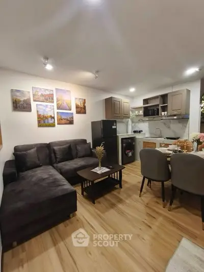 Modern open-layout living room with cozy seating and stylish kitchen area