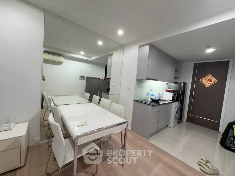Modern kitchen and dining area with sleek design and integrated appliances in a contemporary apartment.