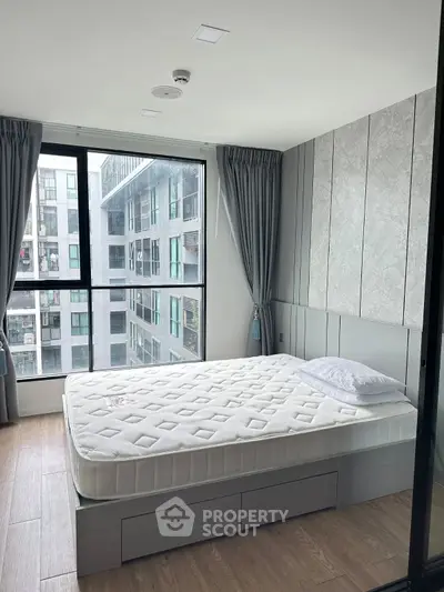 Modern bedroom with large window and stylish decor in urban apartment