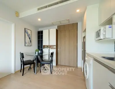Modern kitchen with dining area, featuring sleek appliances and stylish decor in a contemporary apartment.