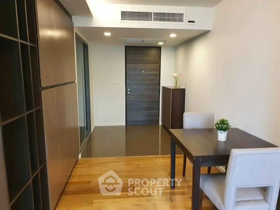 Modern apartment entrance with stylish dining area and wooden flooring