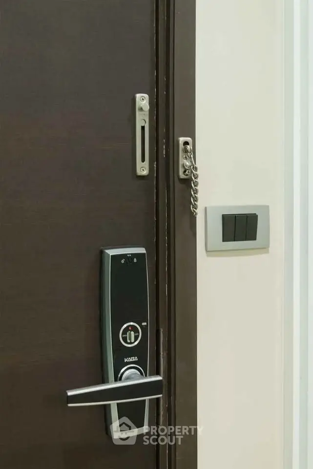 Modern apartment door with electronic lock and security chain, showcasing advanced home security features.