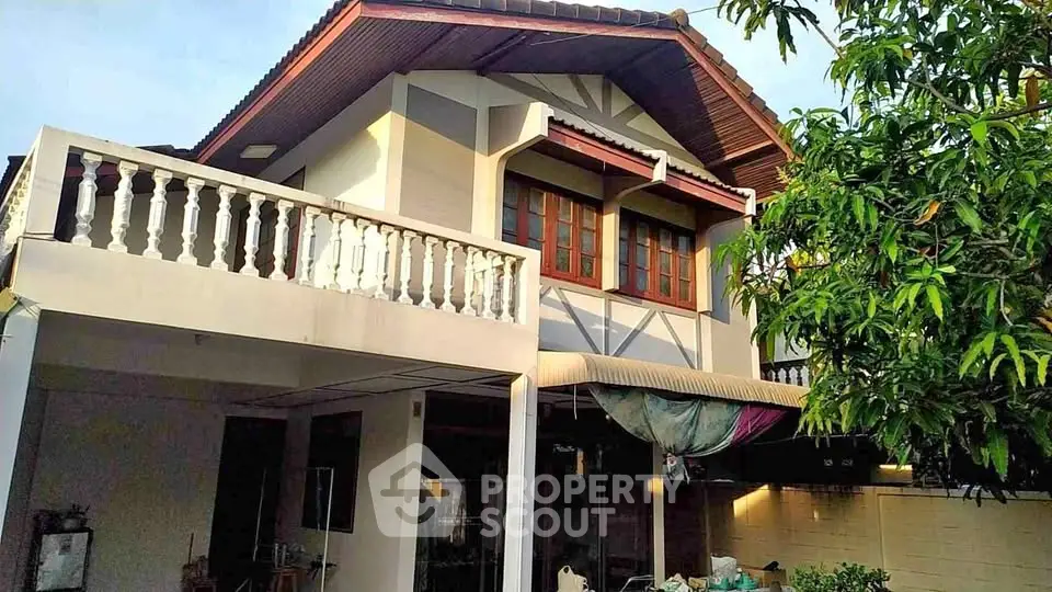 Charming two-story house with balcony and lush greenery