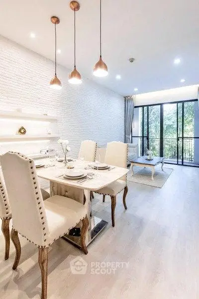 Elegant dining and living area with stylish decor and large windows for natural light.