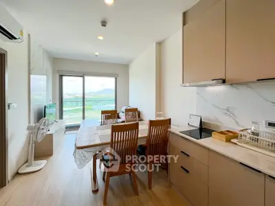Modern dining area with open kitchen and scenic balcony view