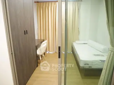 Modern bedroom with glass partition and cozy workspace, featuring a comfortable bed and stylish decor.