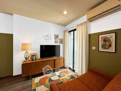 Stylish living room with modern decor, featuring a cozy sofa, TV unit, and vibrant artwork, perfect for relaxation.