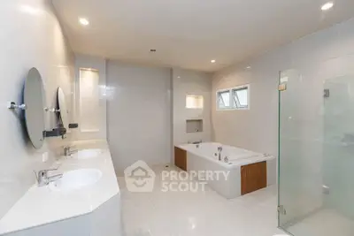 Spacious modern bathroom with dual sinks and a luxurious bathtub.