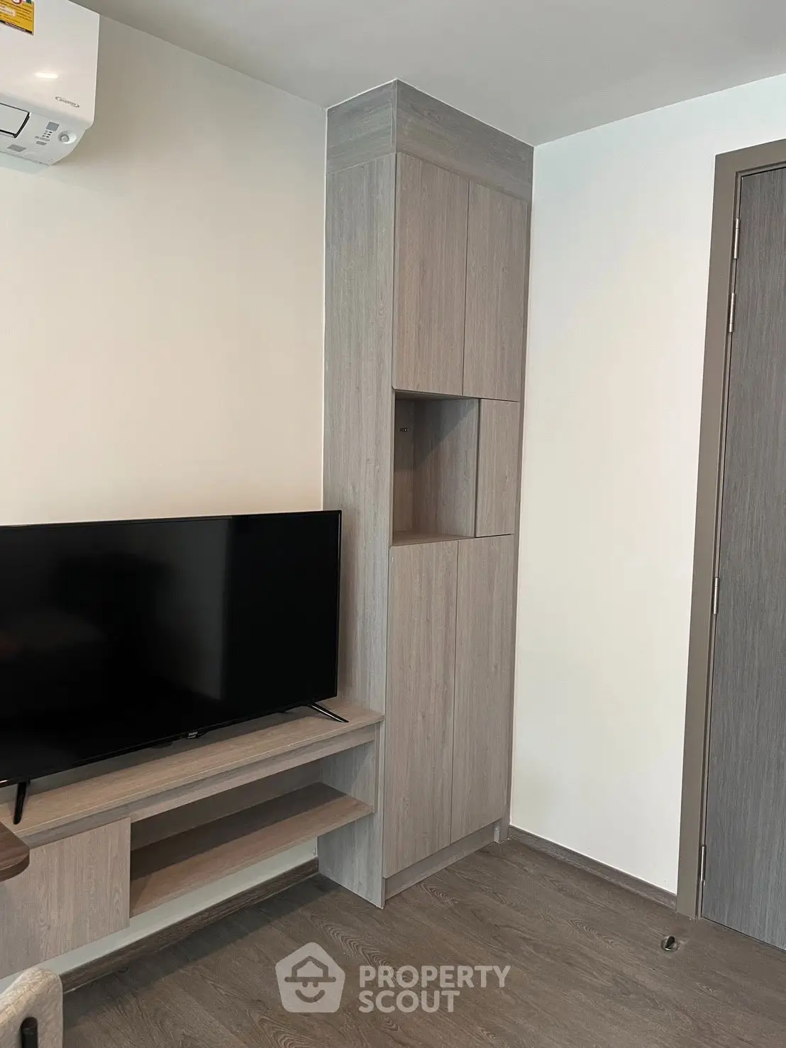 Modern living room with sleek TV setup and stylish wooden cabinetry