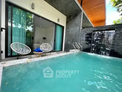 Luxurious modern villa with private pool and waterfall feature, perfect for relaxation and entertainment.